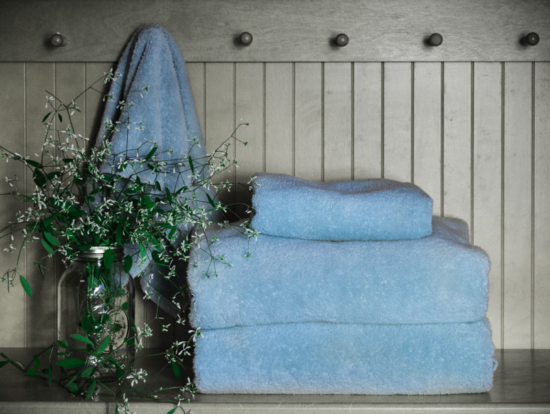 towels stacked on a shelf with flowers